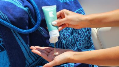 Persona aplicando crema solar en la playa