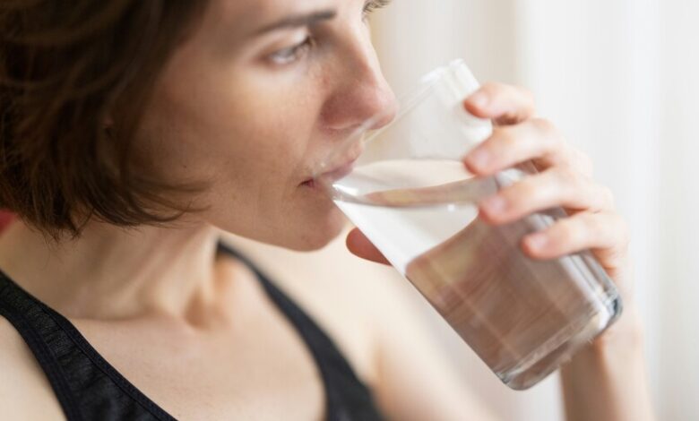 Una persona bebiendo un vaso de agua en la mañana