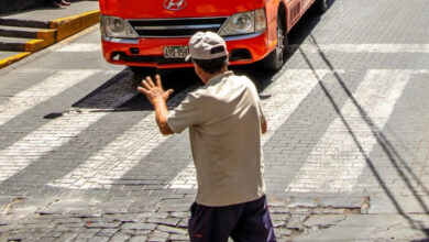 Persona saludando a un conductor en la calle