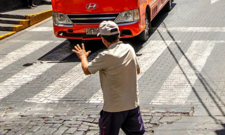 Persona saludando a un conductor en la calle