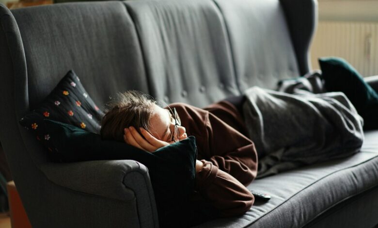Persona durmiendo en una hamaca, con un libro en la mano