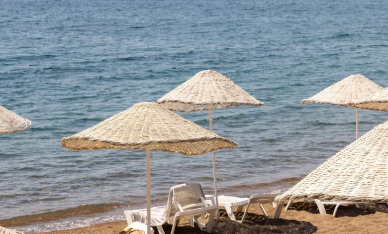 Persona disfrutando del sol en la playa con sombrilla
