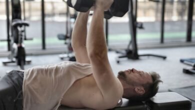 Persona mayor realizando ejercicios de musculación en una sala de gimnasio