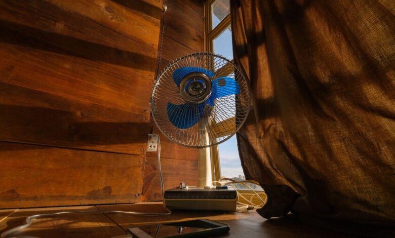 Persona refrescándose con un ventilador en un día caluroso