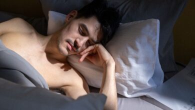 Ilustración de un ser humano dormido con un termómetro en la mano, rodeado de calor y humo