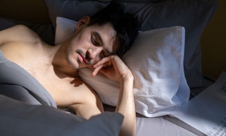 Ilustración de un ser humano dormido con un termómetro en la mano, rodeado de calor y humo