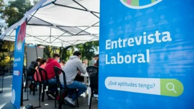 Personas en una oficina, trabajando en equipo, con ordenadores y papeles sobre una mesa