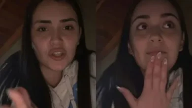 Una persona sentada en una silla, con la cabeza en las manos, mirando una pantalla de computadora con una expresión de tristeza