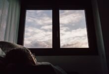 Persona durmiendo en una cama con la ventana abierta