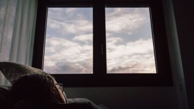 Persona durmiendo en una cama con la ventana abierta