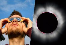 Imagen de un eclipse solar con personas observando con gafas de protección