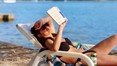 Persona exhausta sentada en la arena bajo el sol de una playa de la zona cordobesa
