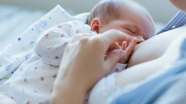 Madre amamantando a su bebé en un entorno tranquilo y apoyo