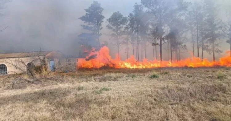 Helicóptero realizando descarga de agua en un incendio forestal
