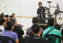 Persona reparando una bicicleta con herramientas en una mesa de trabajo