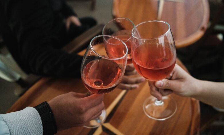 Grupo de amigos brindando con vino tinto en una mesa, resaltando la interacción social