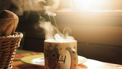 Taza de café humeante sobre una mesa de madera, resaltando la alta temperatura del líquido