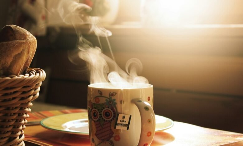Taza de café humeante sobre una mesa de madera, resaltando la alta temperatura del líquido
