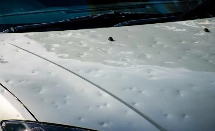Auto dañado por granizo en una calle de Córdoba con vidrios rotos y micro‑bollos en la carrocería