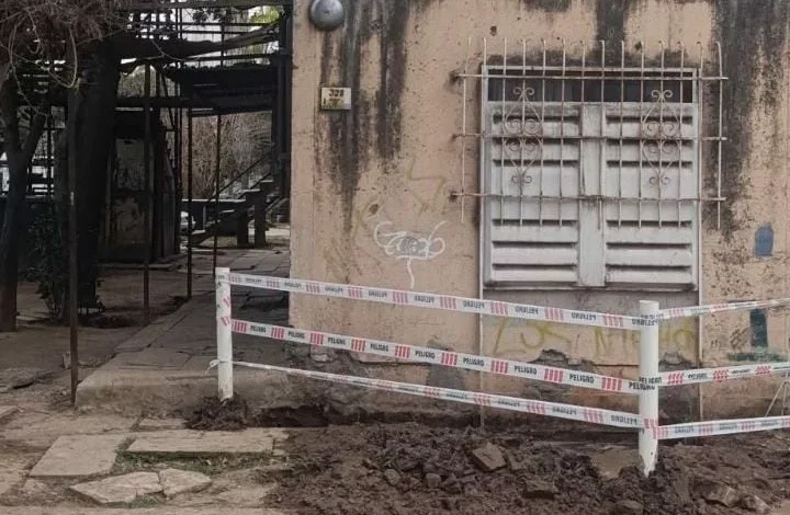 Edificio del barrio SEP en el oeste de Córdoba con tuberías visibles y residentes protestando