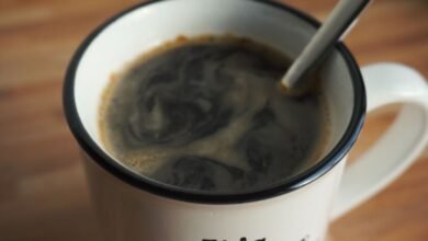 Taza de café humeante sobre una mesa de madera, símbolo de la rutina matutina